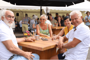 Genietende mensen aan tafel tijdens open huis weekend